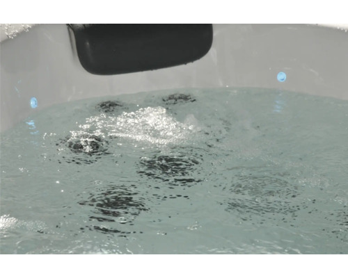 Sprudelndes Wasser in einem Whirlpool mit Kopfstütze und Düsen.