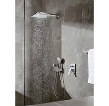 Quadratische Duscharmatur mit Handbrause vor gefliester Wand