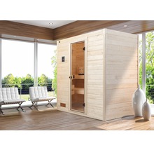 Sauna aus Holz mit Glastür in einem hellen Raum mit Sesseln.