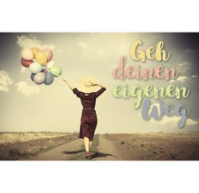 Frau mit Strohhut und Ballons auf einem Feldweg mit dem Schriftzug Geh deinen eigenen Weg