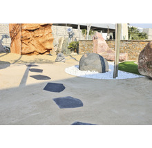 Dekorativer Garten mit Steinen und Trittplatten