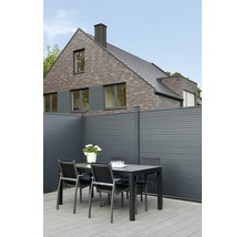 Gartenbereich mit Esstisch, Stühlen und Sichtschutzzaun vor einem Wohnhaus