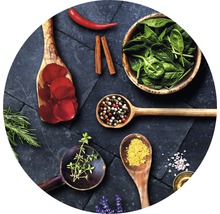 Arrangement aus Kräutern, Gewürzen und Blütenblättern in Holzlöffeln und einer Schüssel