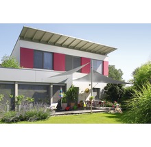 Haus mit Sonnensegel im Garten und Kind auf dem Rasen