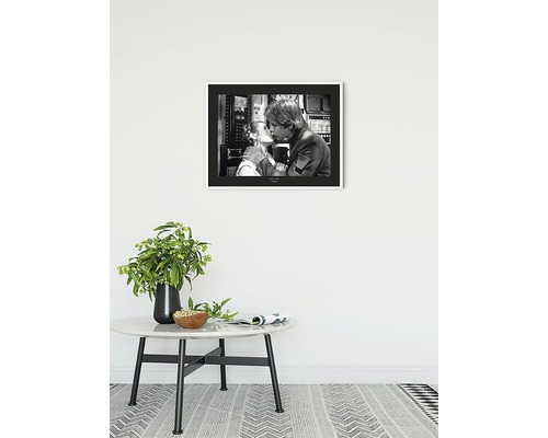 Gerahmtes Schwarzweißfoto von einem Paar, das sich küsst, aufgehängt über einem Beistelltisch mit Blumenvase