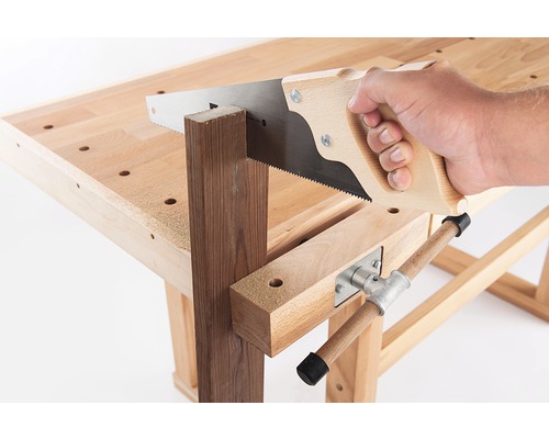 Hand mit Säge sägt Holzstück auf Werkbank