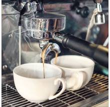 Espressomaschine füllt zwei Tassen mit Kaffee.