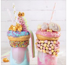 Zwei Milchshakes mit Süßigkeiten und Donuts dekoriert