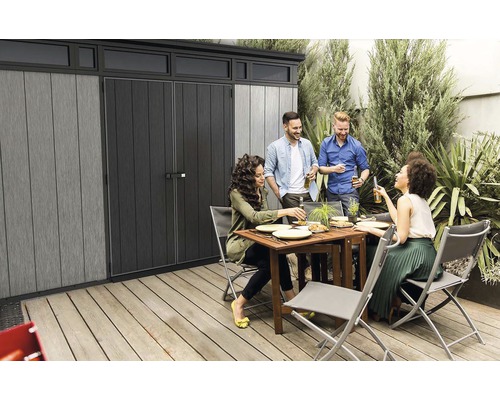 Gartenszene mit Gerätehaus und einer Gruppe von Menschen, die zusammen essen und trinken.