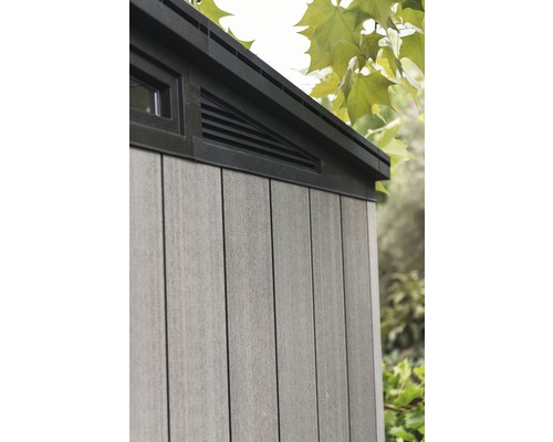 Detailansicht eines Gerätehauses mit Fenster und Lüftungsgitter.