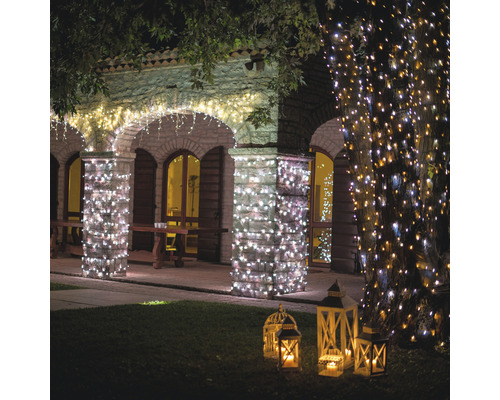Beleuchtetes Gebäude mit Lichterketten und Laternen im Garten