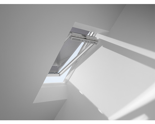 Dachfenster mit geöffnetem Fensterflügel und Rollo im weißen Raum
