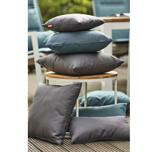 Verschiedene graue und blaue Kissen auf einem Tisch und einem Holzboden