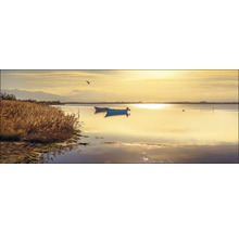 Seelandschaft mit Booten und Schilf im goldenen Licht
