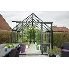 Gewächshaus mit Pflanzen und Gartenzubehör
