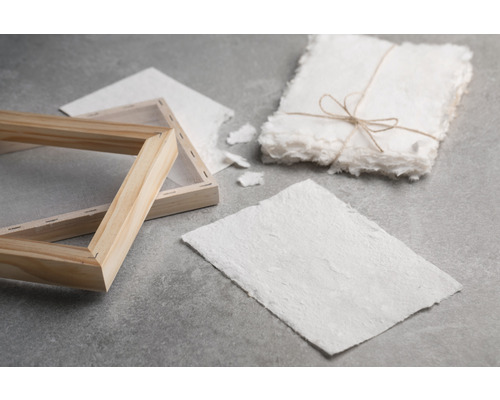 Papierschöpfrahmen mit Papierbogen und Papierstapel