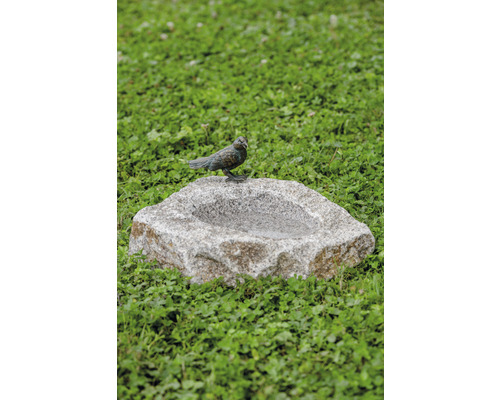 Vogeltränke aus Stein mit Vogel-Dekoration im Garten