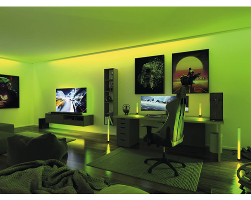 Beleuchtetes Spielzimmer mit Schreibtisch, Stuhl, Computern, Regalen und Dekorationen