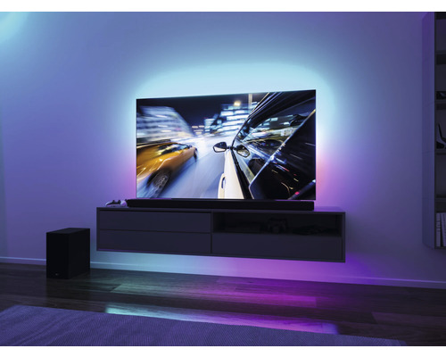 Wohnzimmer mit Fernseher, Soundbar, Subwoofer und indirekter Beleuchtung
