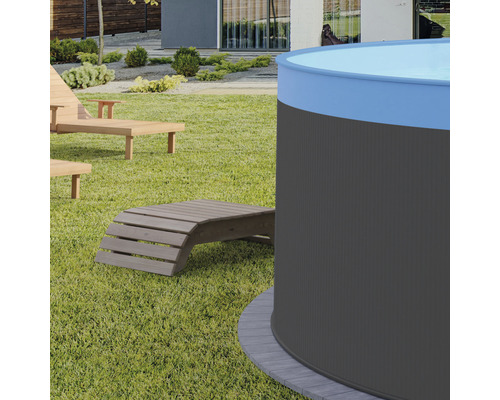 Gartenansicht mit Rundpool und Holzliegen auf Rasenfläche