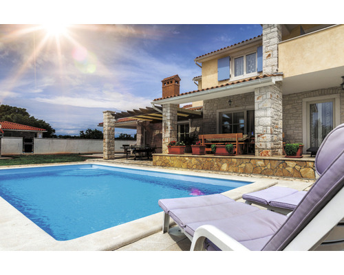 Außenaufnahme eines Hauses mit Pool, Terrasse, Liegestühlen und Gartenmöbeln.