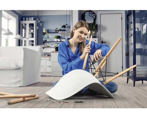 Frau montiert Stuhl in hellem Wohnraum