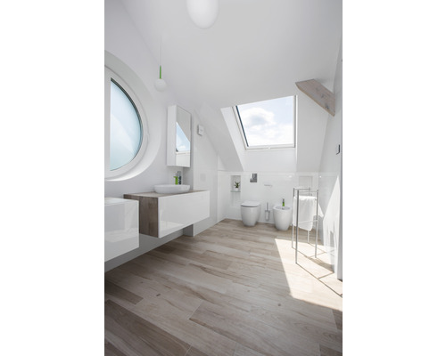 Helles Badezimmer mit Dachfenster, Waschbecken, Toilette und Bidet.
