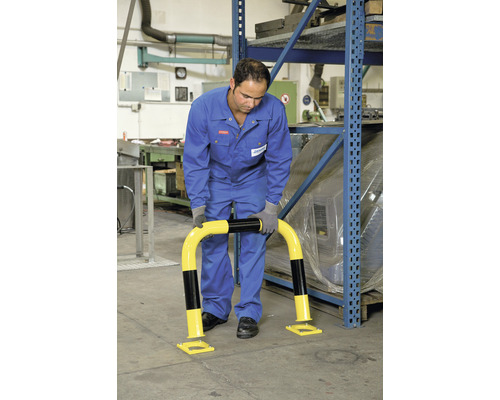 Mann montiert einen Anfahrschutzbügel in einem Lager.