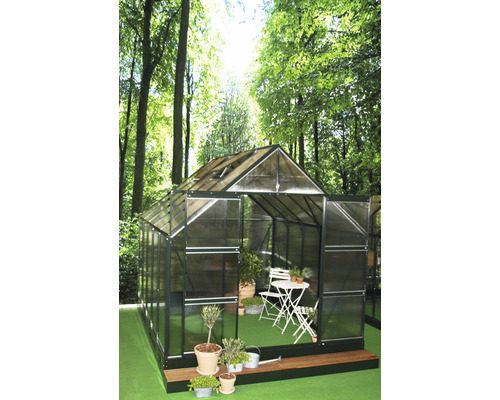 Gewächshaus Halls Magnum 108 8,3 m² Hohlkammerplatten 6 mm 257x322 cm grün Gewächshaus mit Pflanzen und Sitzgruppe im Garten