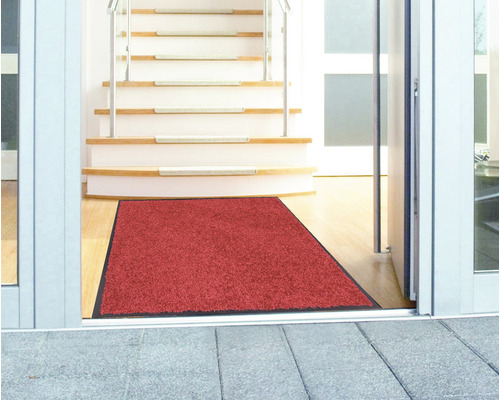 Rote Schmutzfangmatte im Eingangsbereich vor einer Treppe