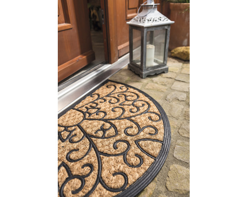 Halbrunde Fußmatte mit dekorativem Muster vor einer Haustür