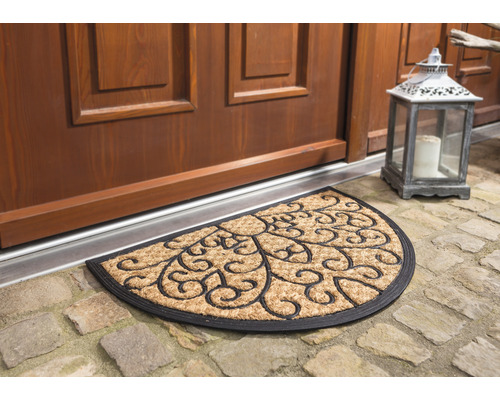 Halbmondförmige Fußmatte mit floralem Muster vor einer Haustür
