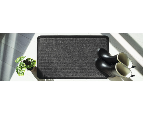 Fußmatte mit Gummistiefeln und Topfpflanze