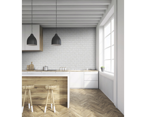 Helle Küche mit Holzboden, weißen Schränken und einer Backsteinmauer