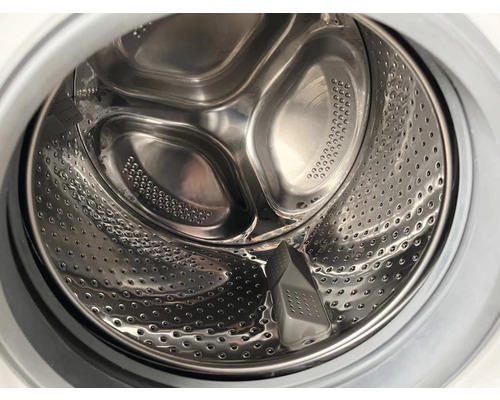 Innenansicht einer Waschmaschinentrommel aus Metall mit Löchern