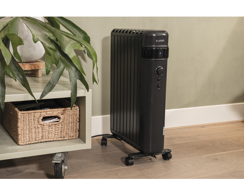 Elektrischer Radiator mit Rollen neben einem Beistelltisch