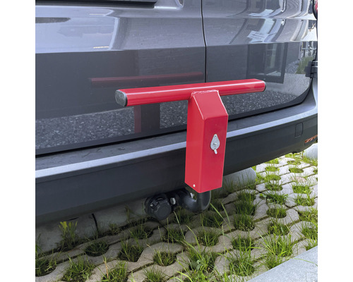 Rote Diebstahlsicherung an der Anhängerkupplung eines Fahrzeugs.