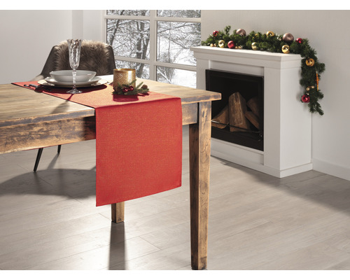 Festlich gedeckter Esstisch mit rotem Tischläufer und Weihnachtsdekoration