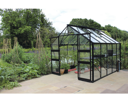 Gewächshaus mit geöffneten Fenstern und Tür in einem Garten