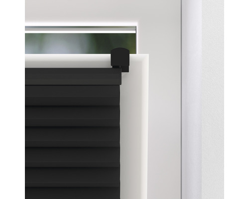 Detailansicht einer schwarzen Faltjalousie an einem Fenster