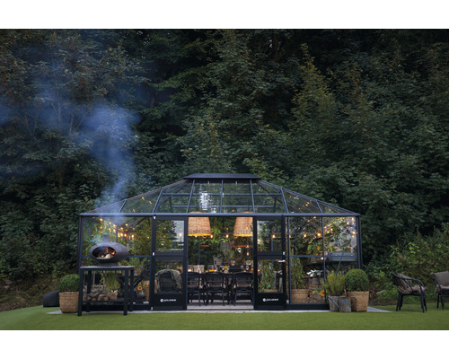 Gewächshaus mit Esstisch, Beleuchtung und Pizzaofen im Garten