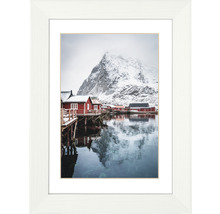 Gerahmtes Poster mit einem Winterdorf in Norwegen mit Berg im Hintergrund