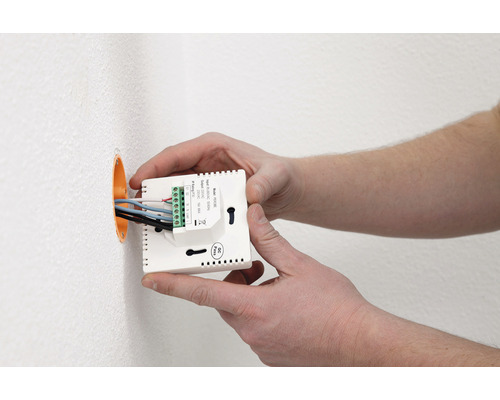 Installation eines Raumtemperaturreglers mit Anschlussklemmen an einer Wand
