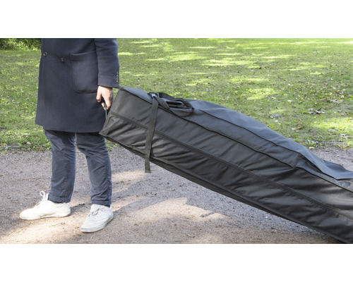 Person transportiert eine große schwarze Tragetasche im Freien.