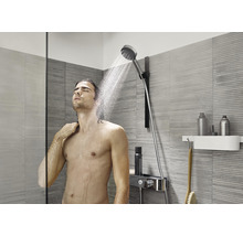 Mann unter einer Handbrause in einem modernen Badezimmer