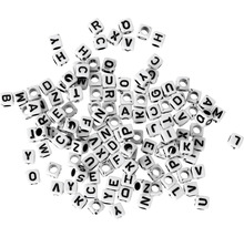 Viele weiße, würfelförmige Buchstabenperlen mit schwarzen Aufdruck