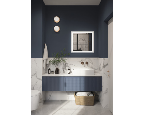 Badezimmer mit Waschtisch, Spiegel mit Beleuchtung, Handtuch und Dekoration