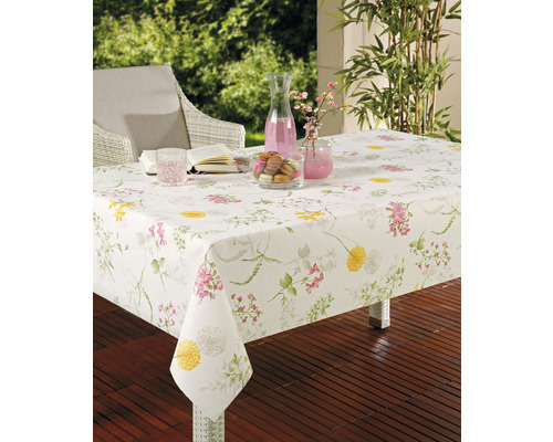 Tischszene mit weißer Tischdecke mit Blumenmuster im Außenbereich