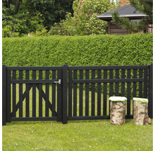 Schwarzer Holzzaun mit Gartentür und Baumstammhockern im Garten
