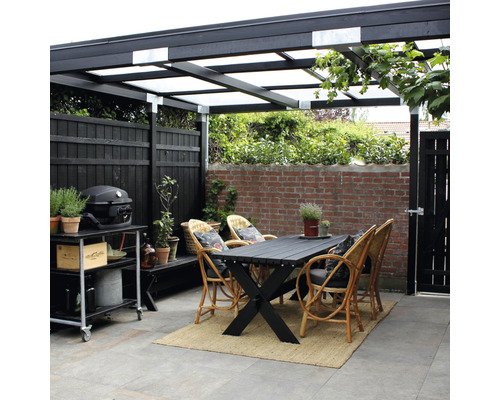 Überdachte Terrasse mit Esstisch, Korbstühlen, Grillwagen und Zaun